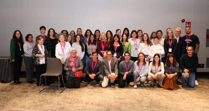 Grupo de personas posando juntas en un evento, con camisetas y bufandas de un color similar.